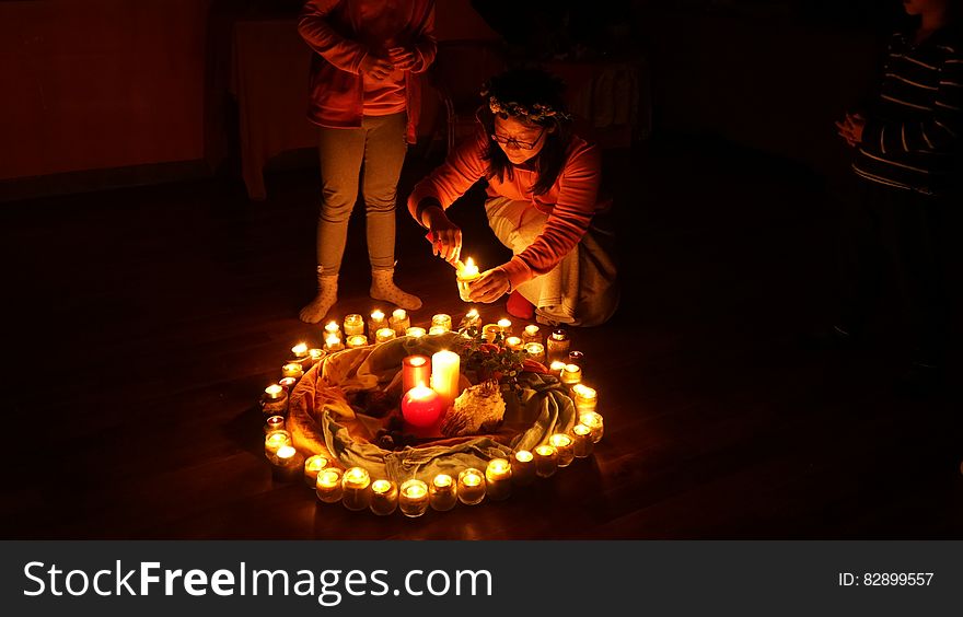 Young girl lighting candle as part of fire ring. Young girl lighting candle as part of fire ring.