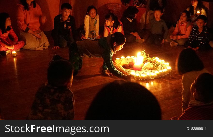 Children sitting in circle on floor around burning candles. Children sitting in circle on floor around burning candles.