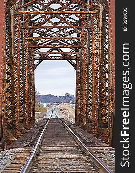 Old rusted railroad bridge with tracks and railroad ties
