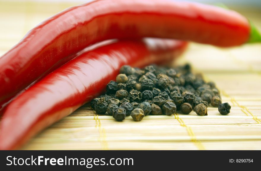 Black and red pepper on a wooden background. Black and red pepper on a wooden background