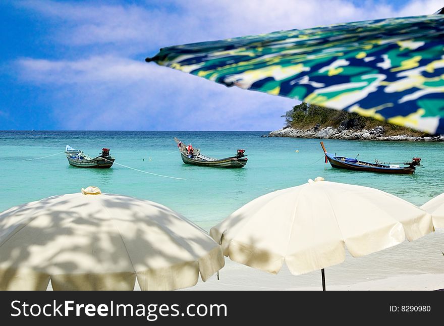 Andaman sea view with sun umbrellas and longtail boats. Andaman sea view with sun umbrellas and longtail boats