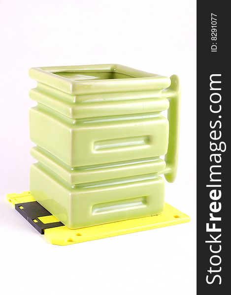 The square mug on a yellow diskette