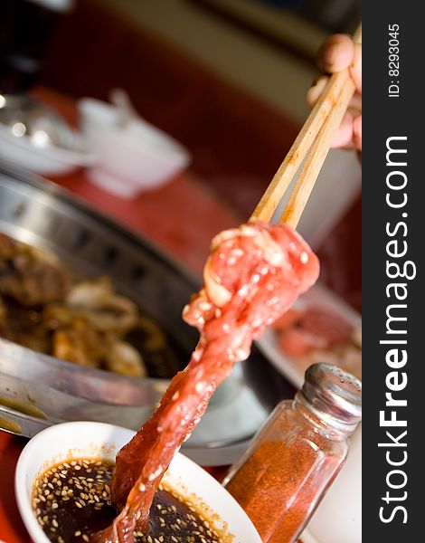 Tasty asian sauce for grilled meat at a japanese restaurant. customer cooking the dish on a grill. Tasty asian sauce for grilled meat at a japanese restaurant. customer cooking the dish on a grill.