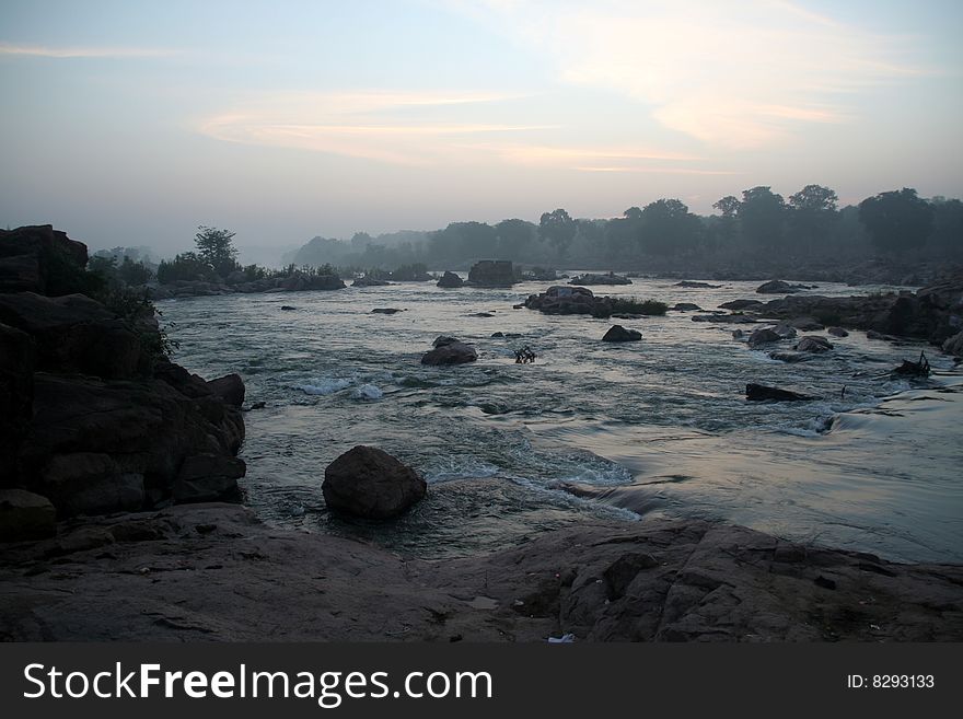 Vast expanse of river water flowing through rocks ferociously. Vast expanse of river water flowing through rocks ferociously