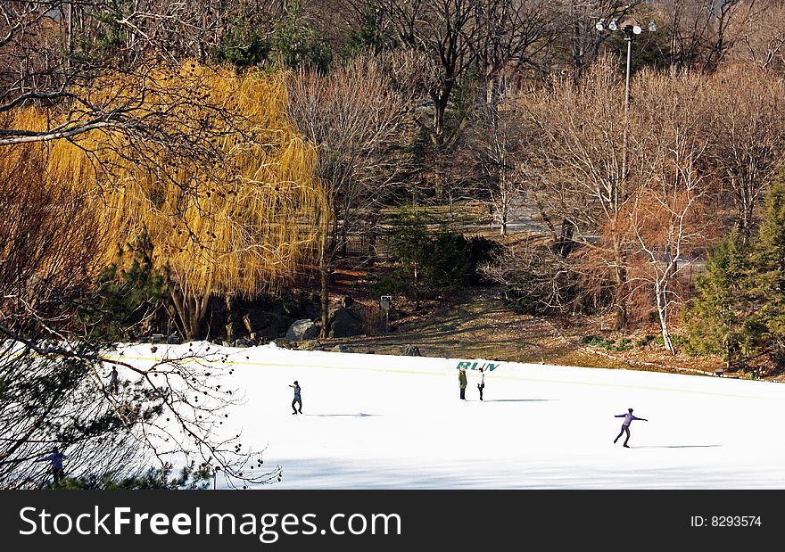 This is an image of people skating in an outdoor rink. This is an image of people skating in an outdoor rink.