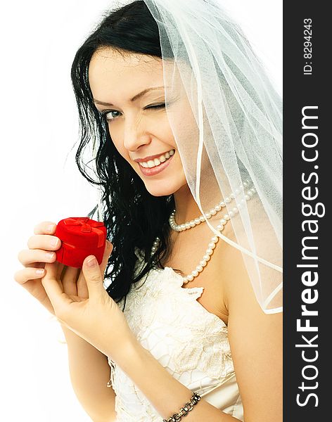 Beautiful young brunette bride holding a wedding ring and winking to us. Beautiful young brunette bride holding a wedding ring and winking to us