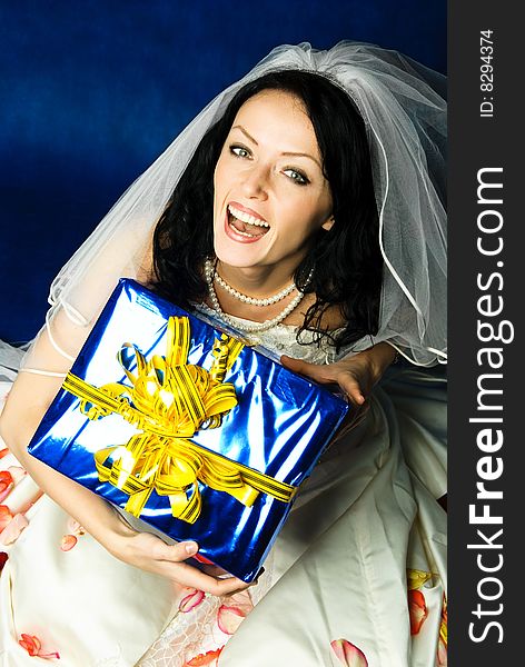 Studio portrait of a happy excited bride with a big present. Studio portrait of a happy excited bride with a big present