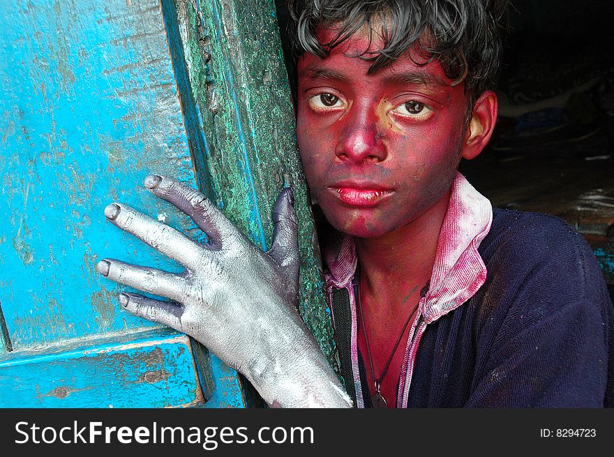 Close up of a boyâ€™s face smeared with colour during the Holi festival in India.
