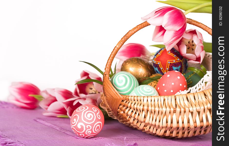 Easter colored eggs in the basket with tulips. Easter colored eggs in the basket with tulips