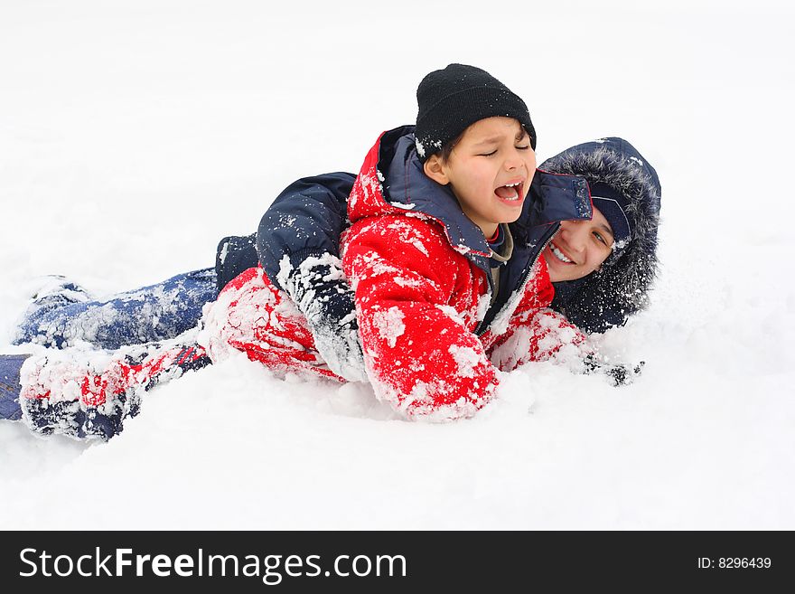 Two boys play, jump and lay down in the snow. Two boys play, jump and lay down in the snow