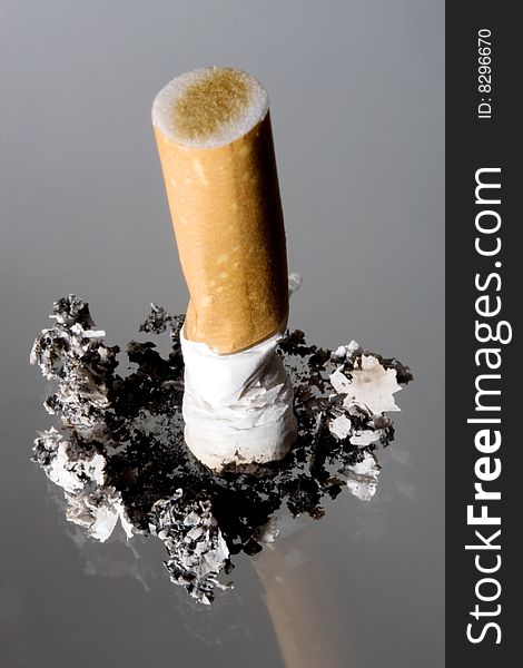 Cigarette stub on grey background
