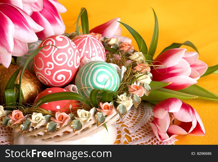 Easter colored eggs in the basket with tulips. Easter colored eggs in the basket with tulips