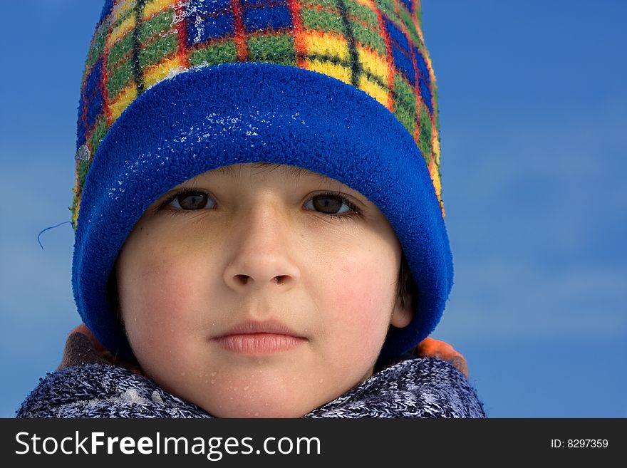 Cute boy winter portrait with blue sky