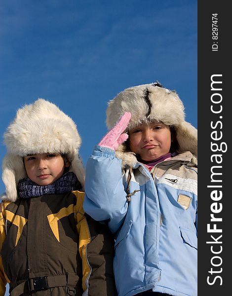 Cute girl and boy in the fur-cap