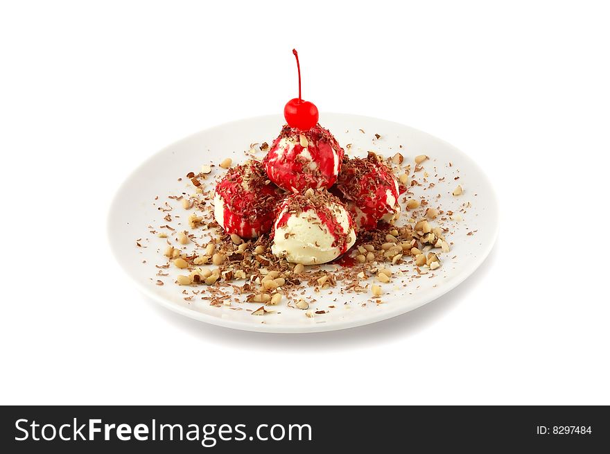 Ice-cream in nuts with a cherry on a white dish
