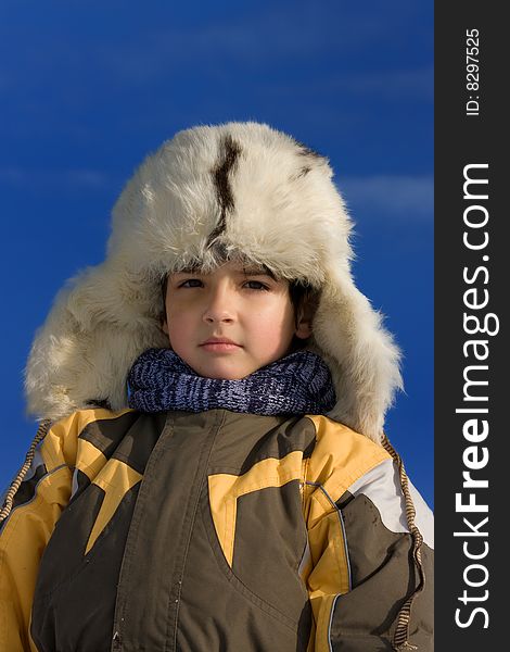 Cute little boy winter portrait in the fur-cap