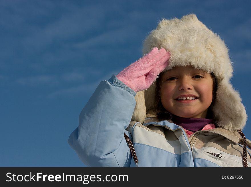 Smilling girl winter portrait in the fur-cap