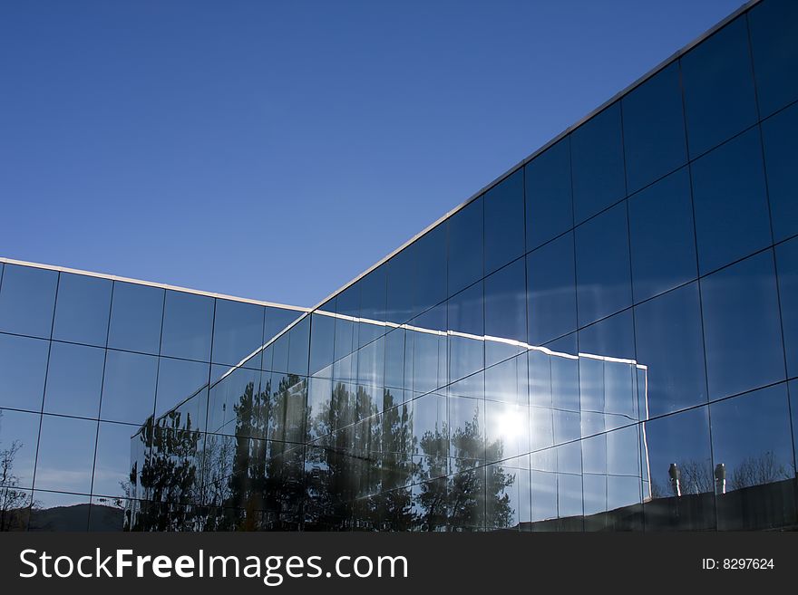 Reflections of the sun in the glass of the modern building.