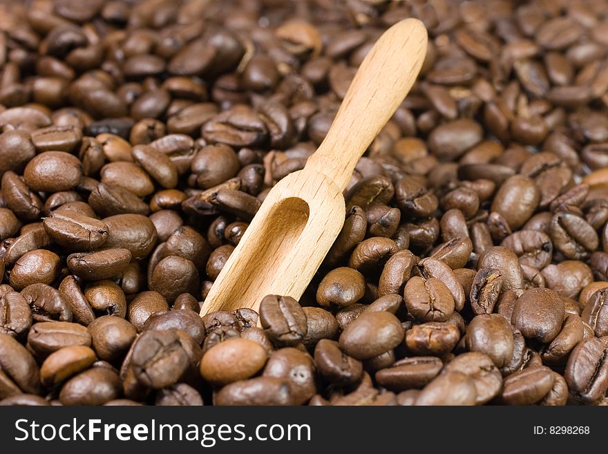 Small wooden scoop among coffee beans