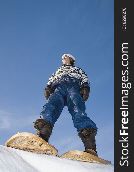 Woman stands on the top of the hill with her snowshoes. Woman stands on the top of the hill with her snowshoes