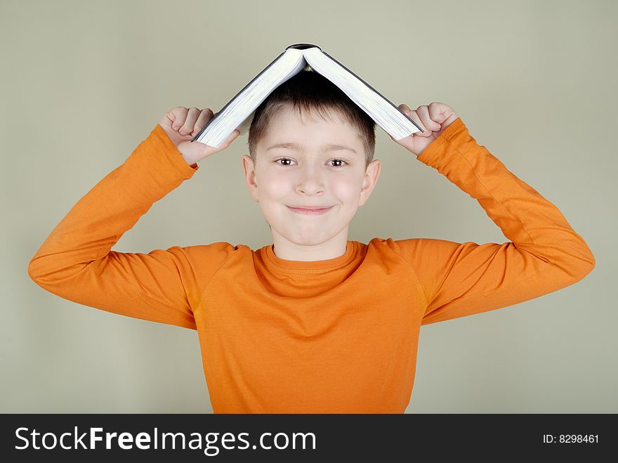 Boy with a book in the form of houses on the head. Boy with a book in the form of houses on the head