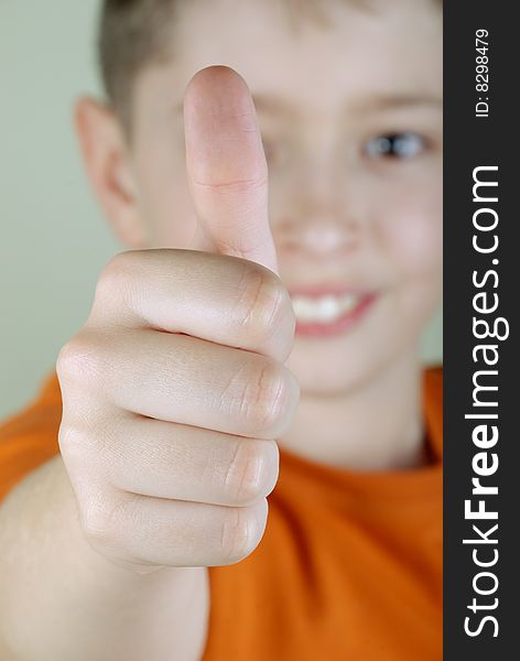 Smiling boy with thumb-up. Close-up