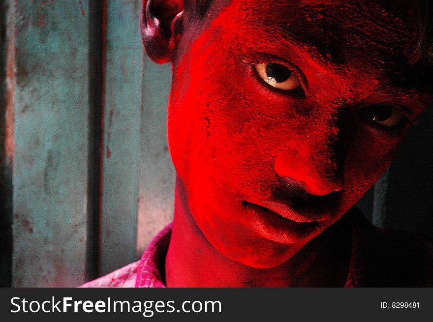 Close up of a boy’s face smeared with red colour during the Holi festival in India. Close up of a boy’s face smeared with red colour during the Holi festival in India.