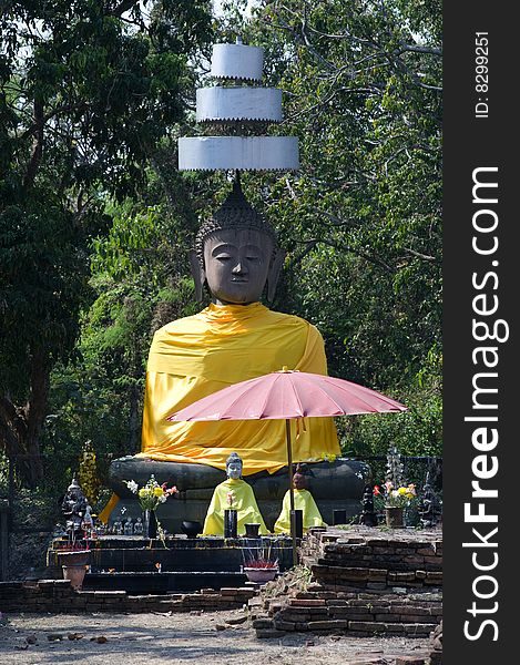 Thailand, the Wat Ku Kan situated in the region of Chiang Mai was founded in a shallow fertile bassin. view of  giant seated buddha. Thailand, the Wat Ku Kan situated in the region of Chiang Mai was founded in a shallow fertile bassin. view of  giant seated buddha