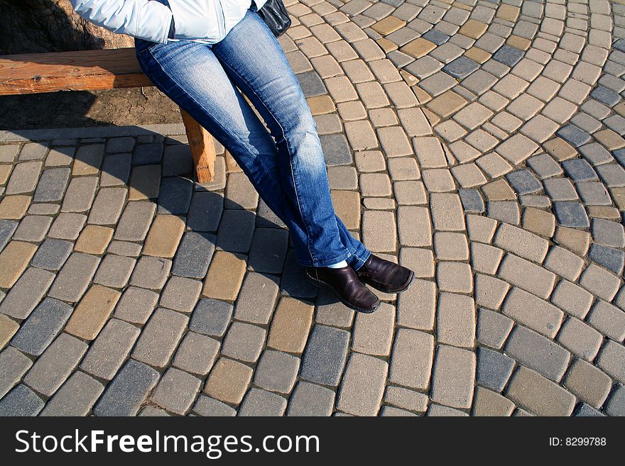 Spring sunny day. The girl sits on a bench. Spring sunny day. The girl sits on a bench