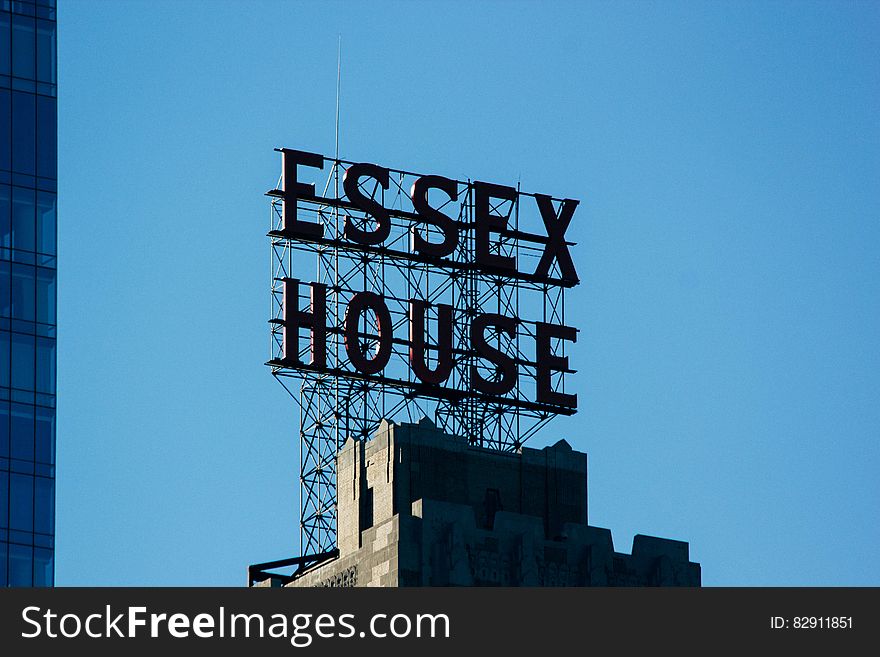 Essex House sign on modern rooftop against blue skies. Essex House sign on modern rooftop against blue skies.