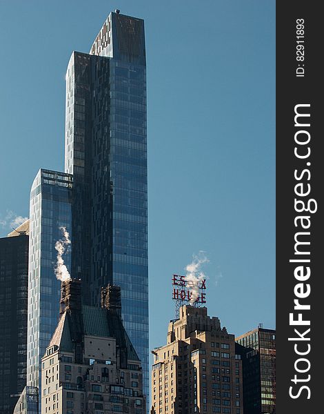 Modern skyscraper against blue skies in modern skyline on sunny day.