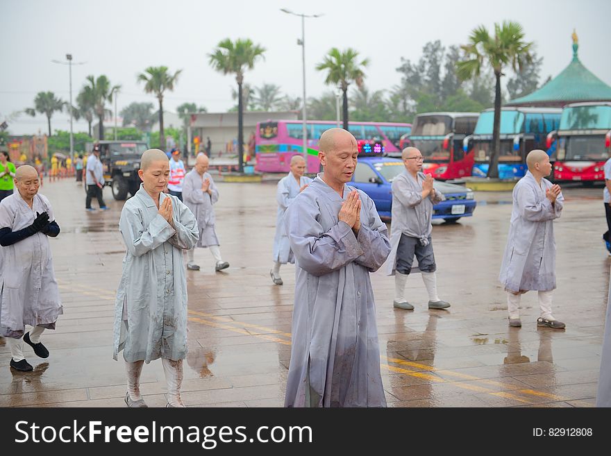 Monks in grey robes in outdoor procession in rain. Monks in grey robes in outdoor procession in rain.