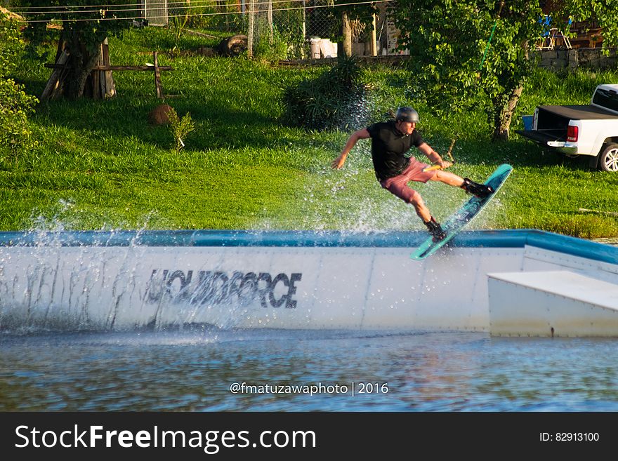 Man riding water board in cement pool on sunny day. Man riding water board in cement pool on sunny day.