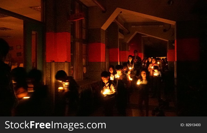 Children holding lit candles in indoor ceremony. Children holding lit candles in indoor ceremony.