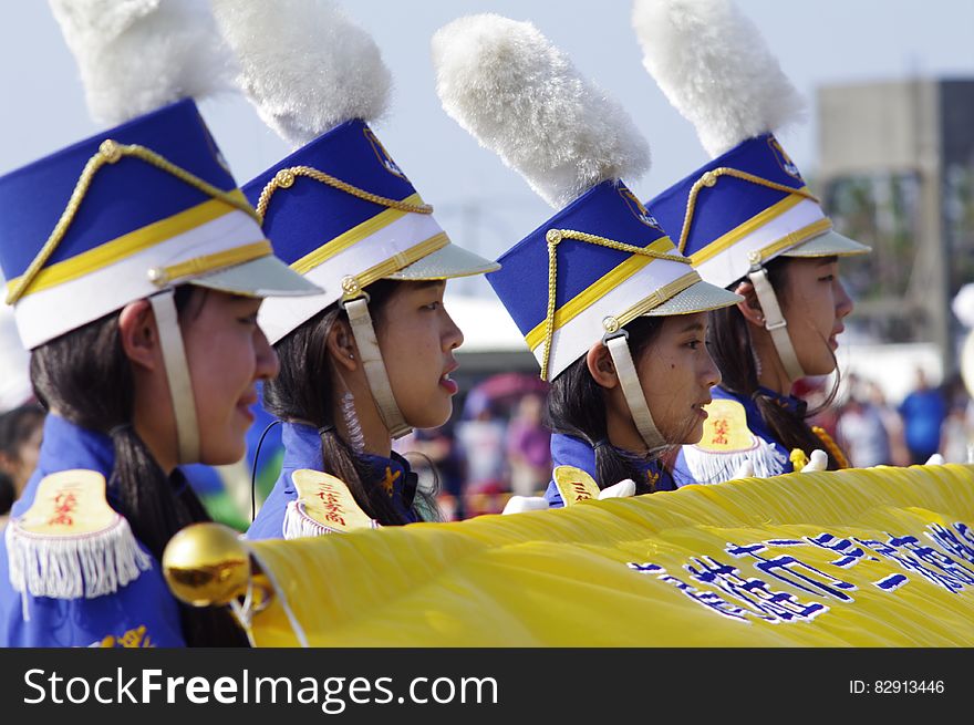 Asian teenage girls in marching band uniforms holding yellow banner. Asian teenage girls in marching band uniforms holding yellow banner.