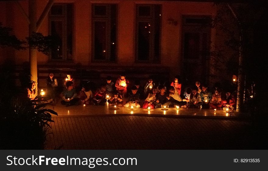 Schoolchildren sitting on floor in candlelight ceremony. Schoolchildren sitting on floor in candlelight ceremony.