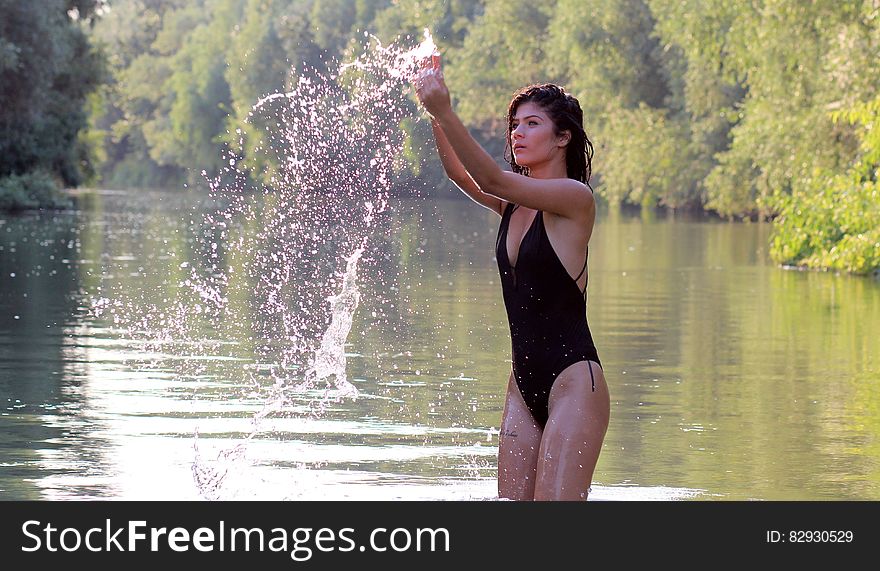 Woman Wearing Black Monokini Playing With Water