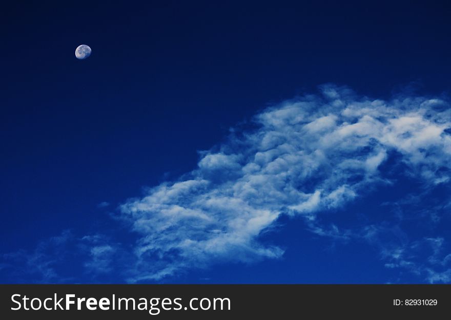 White Clouds Under Blue Sky With Gibbous Moon