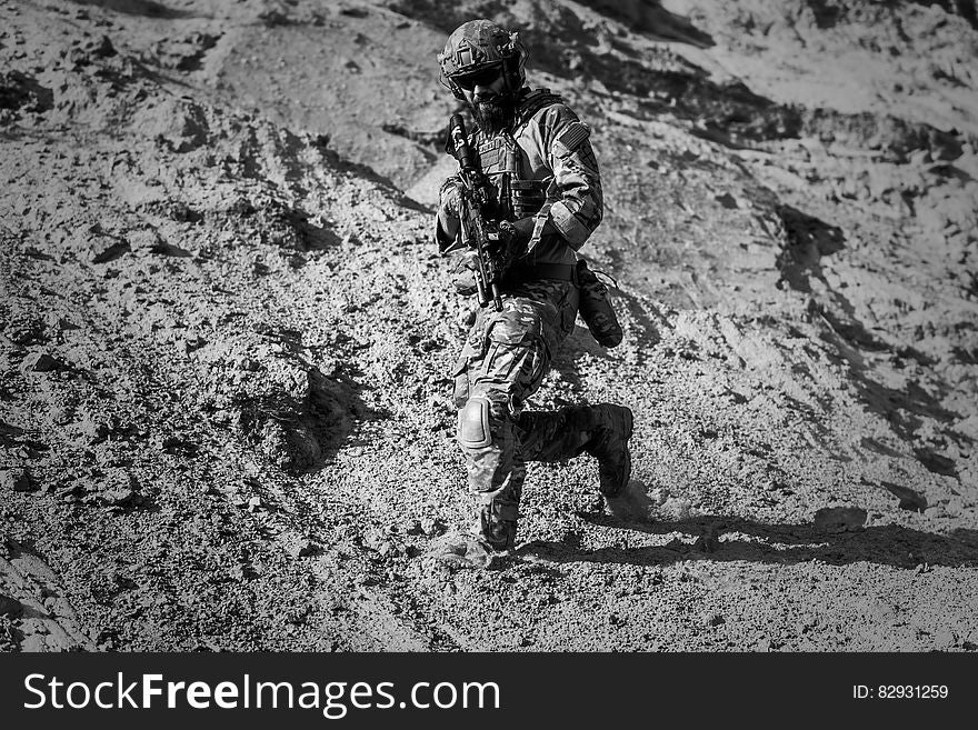 Man In Army Full Combat Uniform Carrying Rifle
