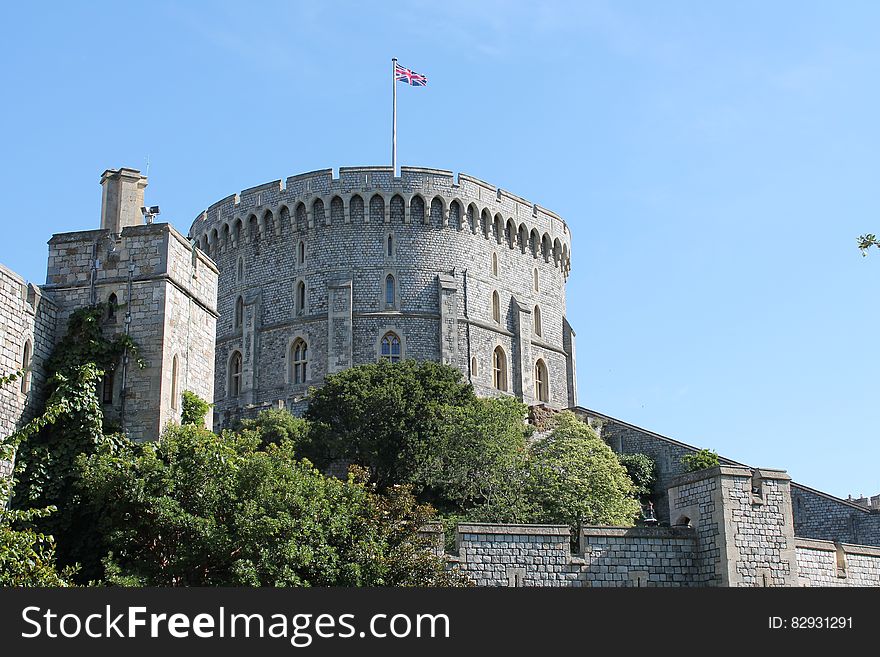 Gray Concrete Castle With Flag on Top Under Blue Sky