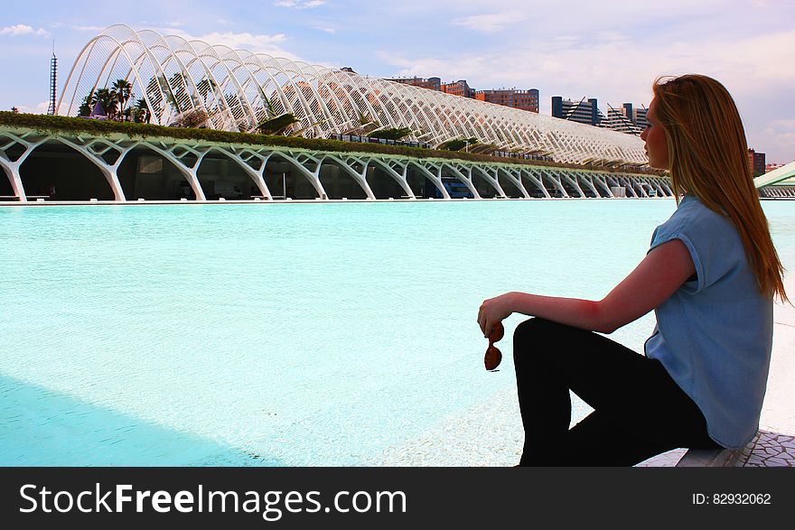 Woman Wearing Blue Shirt In Front Of Green Lake