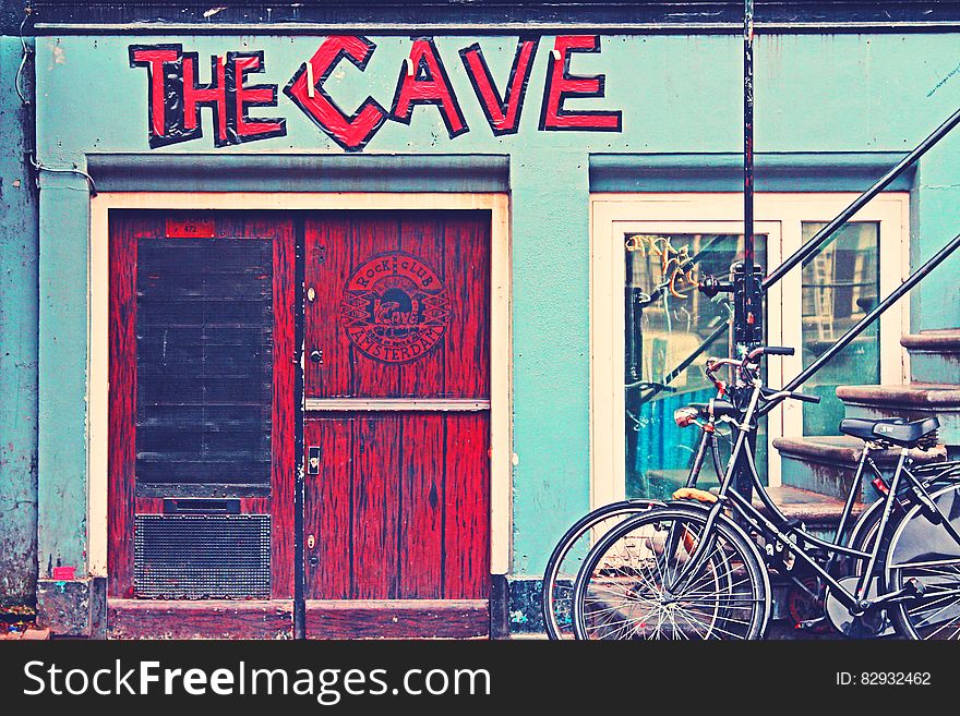 Black Beach Cruiser Bike Beside the Red Wooden Door Outside