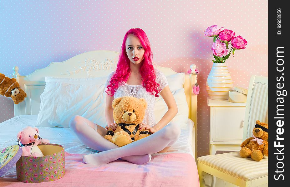 Pink Long Haired Woman Sitting on Double Bed With Bear Plsuh Toy at Daylight