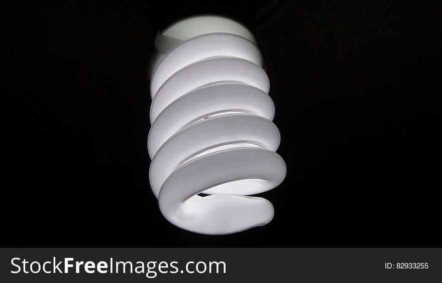 Close up of energy efficient electric light bulb on black background.