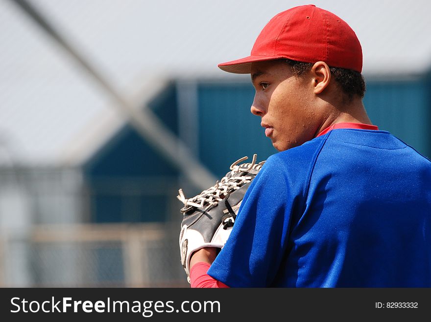 Man in Red Fitted Cap Wearing Blue Shirt With White Leather Baseball Mitt on Hand during Daytime