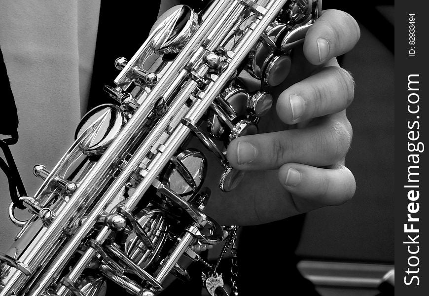 Person Holding Saxophone in Gray Scale Photography