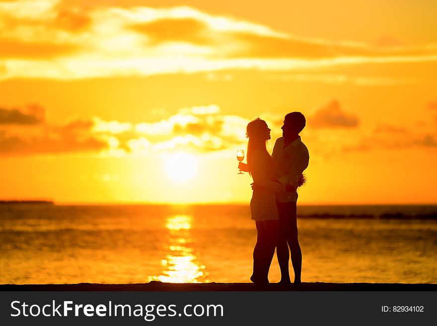 Couple Standing in the Seashore Hugging Each Other during Sunset