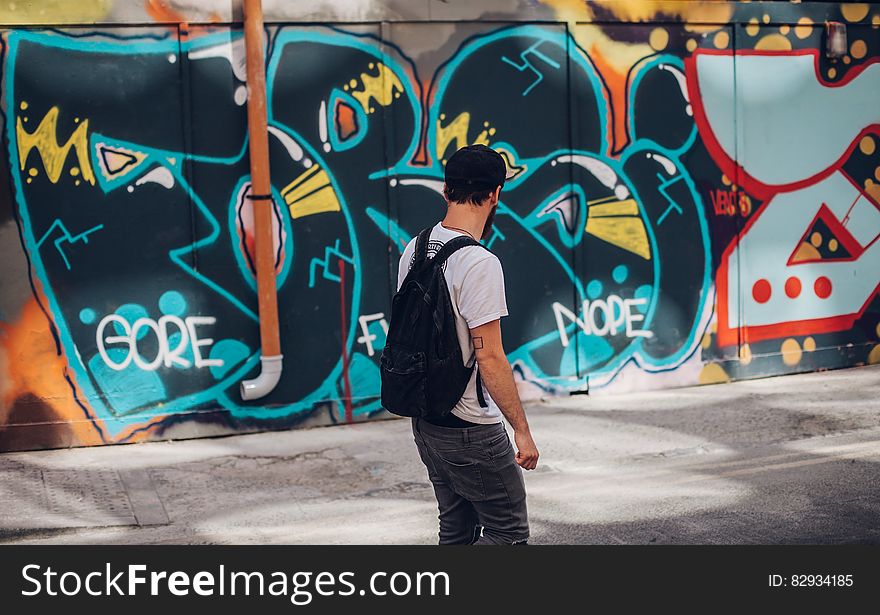 Man In Front Of Wall With Graffiti