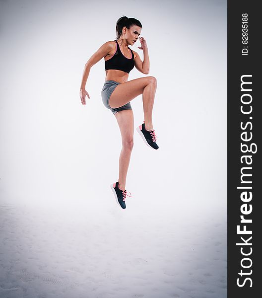 A sporty woman jumping in fitness outfit.