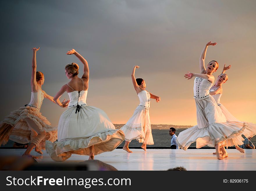 5 Women in White Dress Dancing Under Gray Sky during Sunset